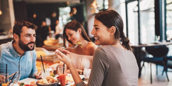 a group of people sitting at a table eating food