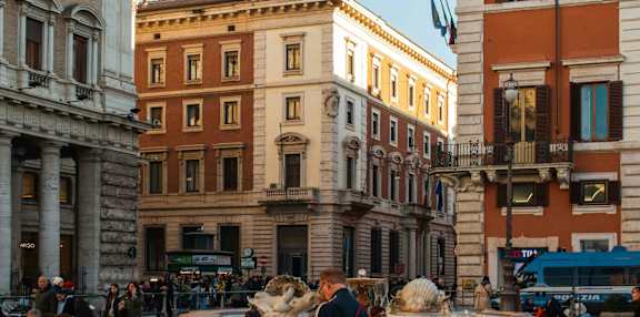 A city street with people walking and buildings in the background.