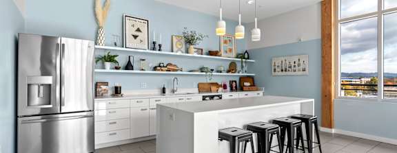 A modern kitchen with a large island and stools.