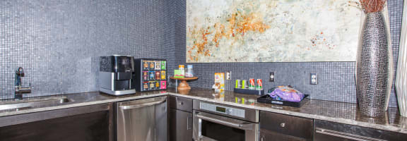 a kitchen with stainless steel appliances and a large painting on the wall at Ovation at Lewisville Apartments, Texas , 75067