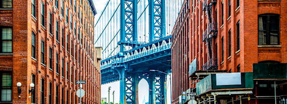 A bridge spans the distance between two rows of buildings.