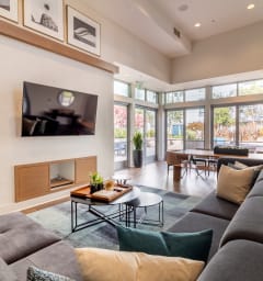 a living room with a large gray couch and a fireplace at Strata at Mission Bay, San Francisco, CA, 94158