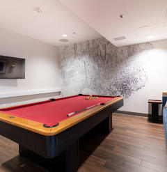 a billiards table in a living room with a red pool table at Strata at Mission Bay, San Francisco, CA, 94158