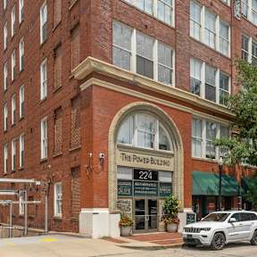 A street view of a building with the sign "The Power Building 224".