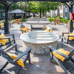 A park with a table and chairs under a canopy.
