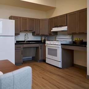 A kitchen with a white refrigerator and a dining table with two bowls on it.