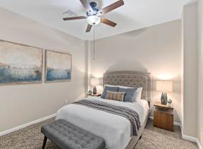 A bedroom with a large bed and a ceiling fan.