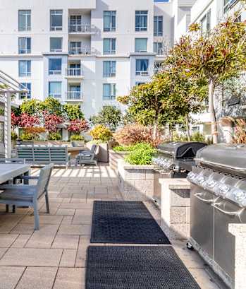 a patio with a table and chairs and a barbecue grill at Strata at Mission Bay, San Francisco