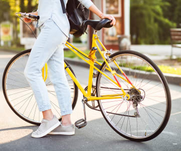 a woman riding a yellow bike on a city street