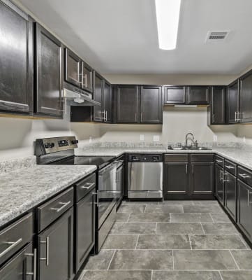 large kitchen with stainless steel appliances, ample cabinetry, and granite-style countertops
