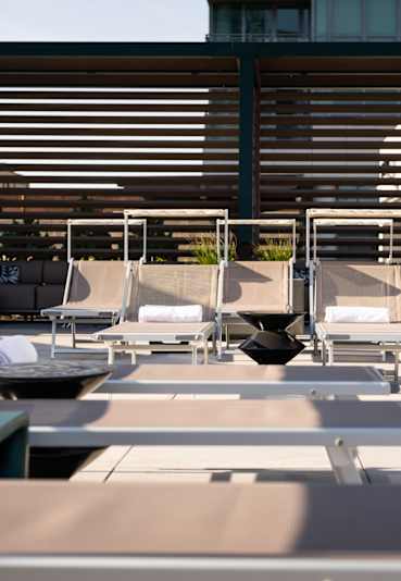 a row of lounge chairs on a patio with a building in the background at Onni Fulton Market Apartments, Chicago, IL, 60661