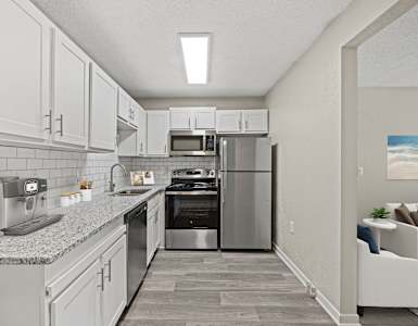 A modern kitchen with stainless steel appliances and white cabinets.
