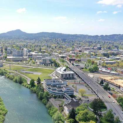 A river flows through a city with a bridge crossing over it.