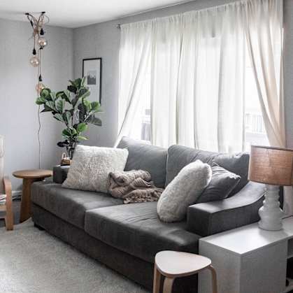 a living room with a gray couch and a white table
