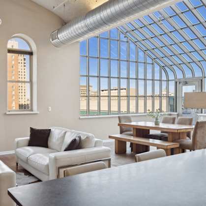 A living room with a glass ceiling and a view of the city.