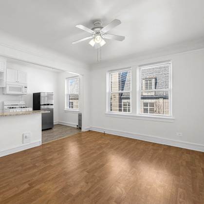 A room with a ceiling fan and wooden flooring at Pleasant Oak Apartments, Oak Park, Illinois