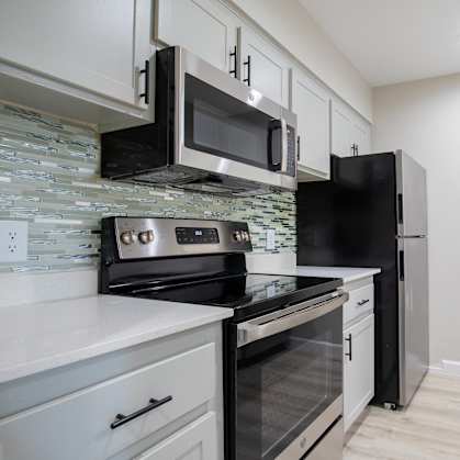 A kitchen with black appliances and white cabinets. at Sofia Apartments, Tempe, AZ, 85283