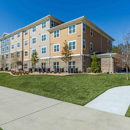 A large apartment complex with a walkway in front.