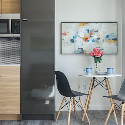 a kitchen with a stainless steel refrigerator and a table with two chairs