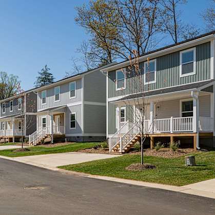 A row of houses with a tree in front of them.