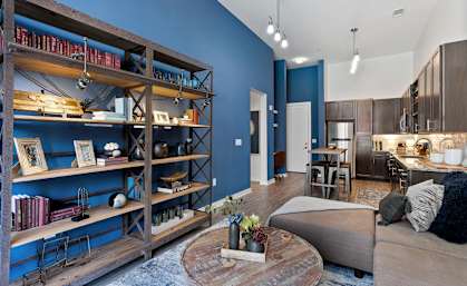 a living room with blue walls and a kitchen with a table