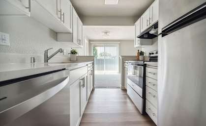 A modern kitchen with white cabinets and stainless steel appliances.
