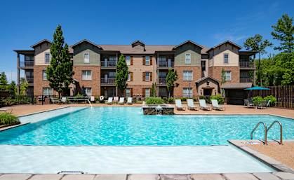 A large apartment complex with a swimming pool in front. at Hall Creek Apartment Homes, Arlington, Tennessee