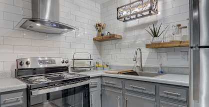 A modern kitchen with stainless steel appliances and white subway tiles.