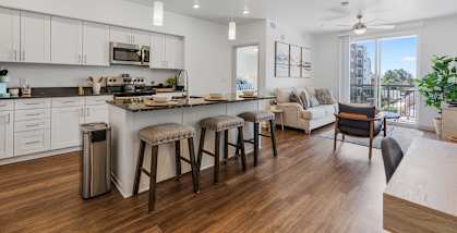 an open kitchen and living room with a large island and stools at City View St. George Apartments, Utah, 84770