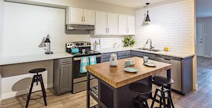 A kitchen with a table and chairs in the middle of it.