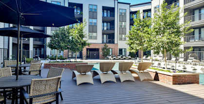 a large patio with tables and chairs and a swimming pool at Station at Old Town, Lewisville, Texas
