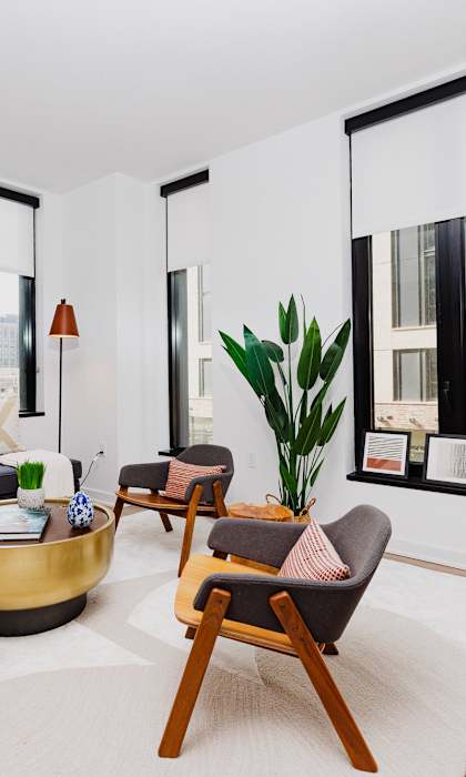 A living room with a black couch, a coffee table, and a chair.