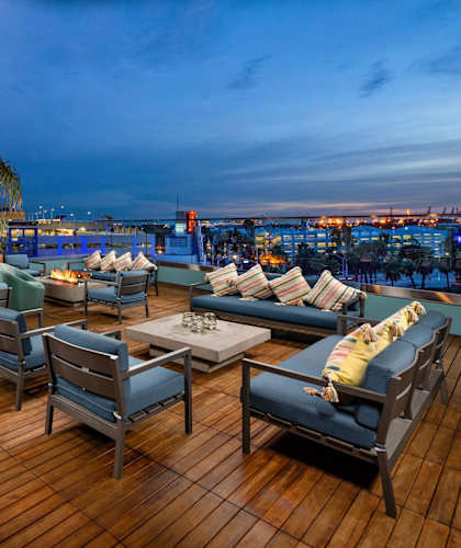 a roof top lounge with a fireplace and a view of the city