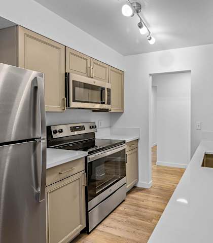 a kitchen with white countertops and stainless steel appliances