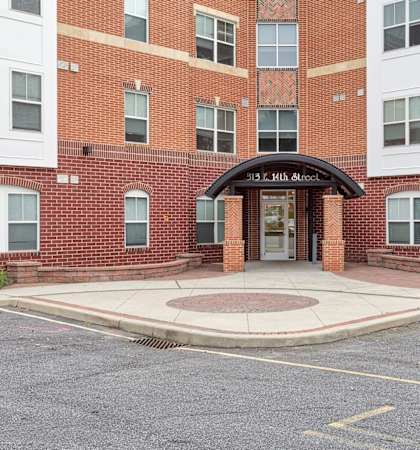 the entrance to a brick building with a sidewalk in front of it