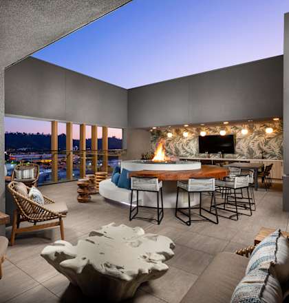 A modern outdoor living space with a fireplace and comfortable seating.