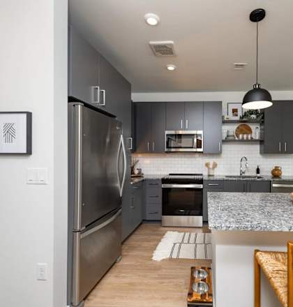 A modern kitchen with a refrigerator, oven, and sink.