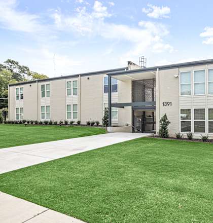 the front of an apartment building with a lawn and sidewalk at The Courts Midtown, Memphis, TN, 38104