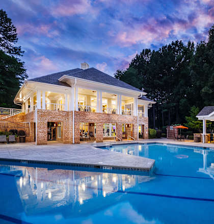 A large house with a pool in front of it.