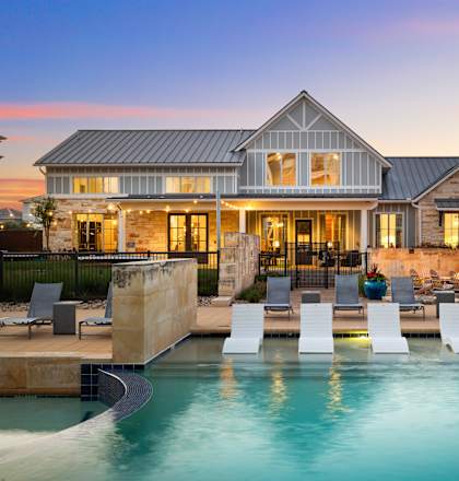 A large house with a pool in front of it.
