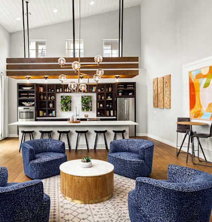 a living room with blue chairs and a bar