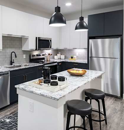 a kitchen with a large island and stainless steel appliances