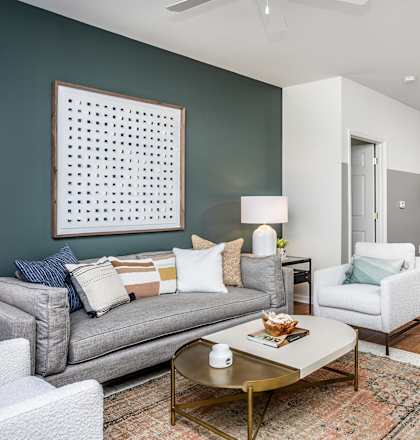 a living room and dining room with a couch and chair and a table with a chair and