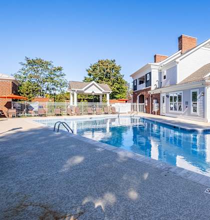 a swimming pool with a house in the background