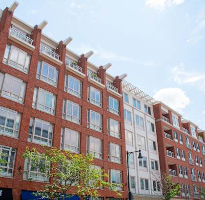 a red brick building with many windows and trees in front of it