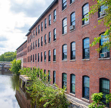 a large red brick building next to a body of water