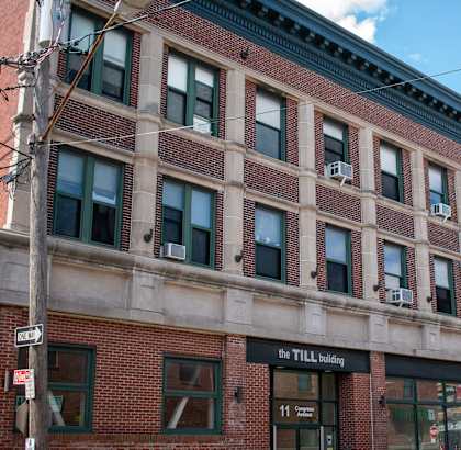 The Till Building is a red brick building with many windows.