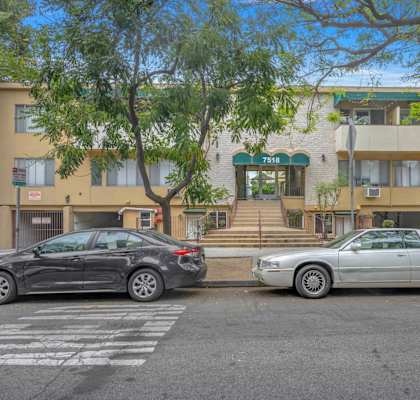 two cars parked in front of an apartment building