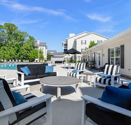 A patio with black and white striped chairs and a round table.