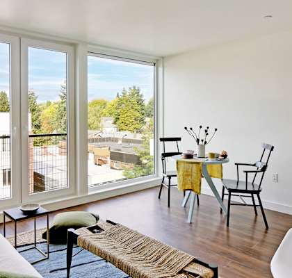 A living room with a table and chairs by a window.